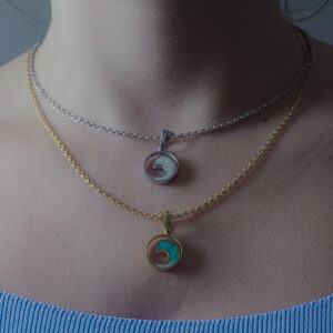 Sea Wave Charm Necklace by Aanyeh Charms, filled with sand. A tribute to the serene and powerful waves of the sea. آنية.